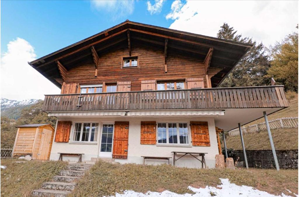 a wooden house with a balcony on top of it at Chalet Alpenmoos (150m2 - max.11) in Lenk