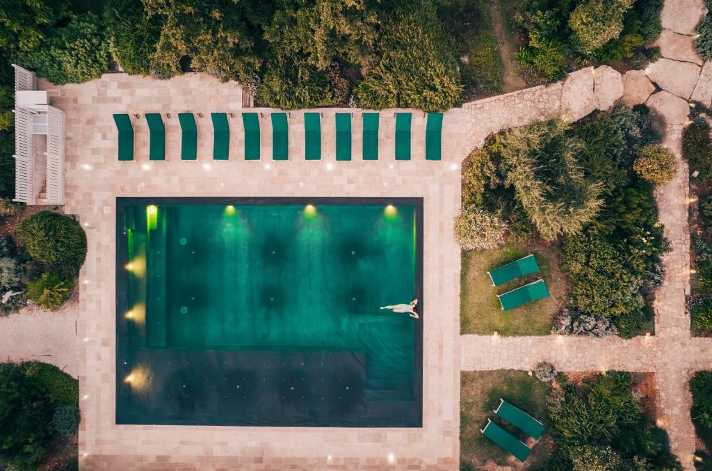 uma vista superior de uma piscina com duas cadeiras em Leonardo Trulli Resort em Locorotondo