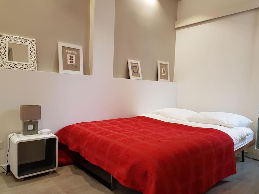 a bedroom with a bed with a red blanket and a tv at Luxury studio in 5 minutes of the Champs-Elysées in Paris