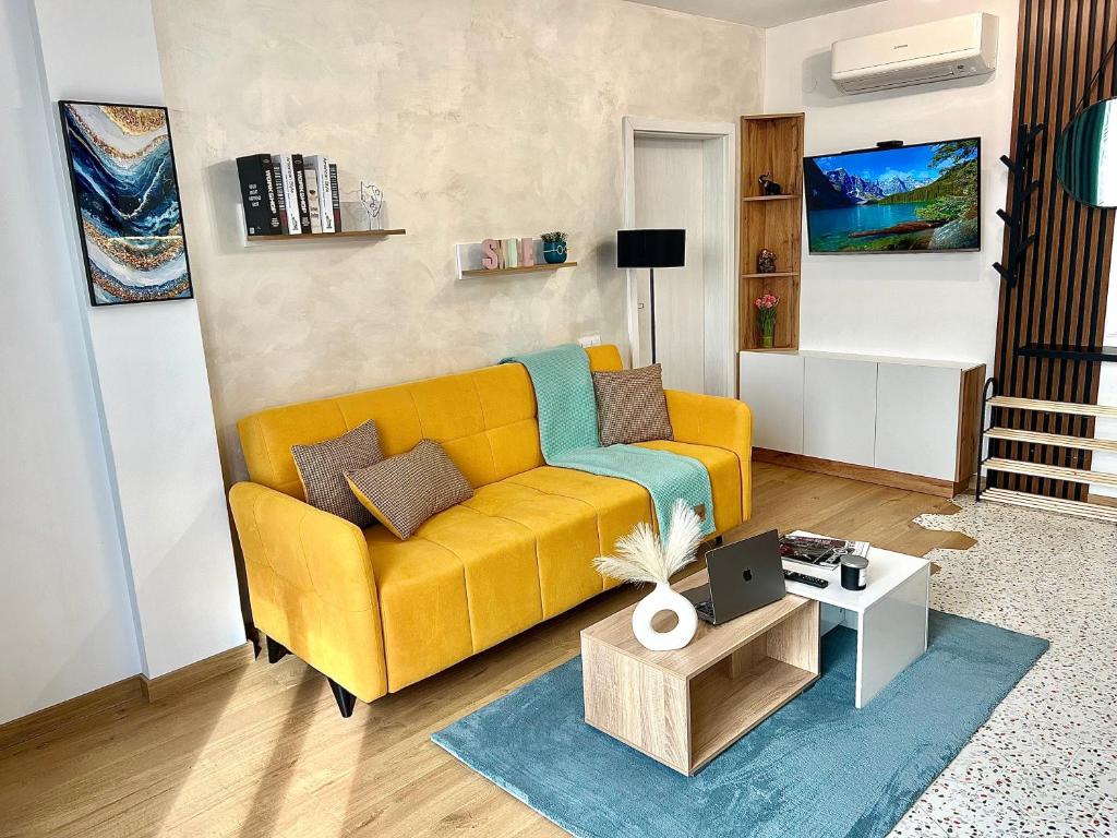 Rio Apart Deluxe في صوفيا: غرفة معيشة مع أريكة صفراء وطاولة