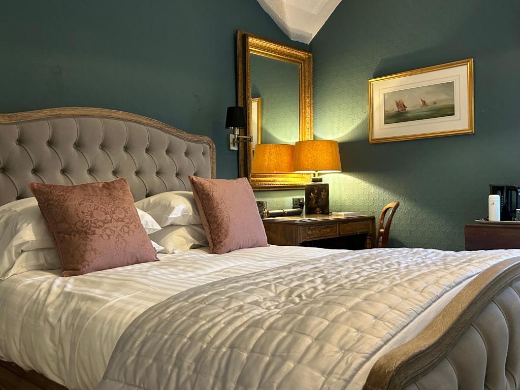 a bedroom with a large bed with a mirror at Baytree House in Harrogate