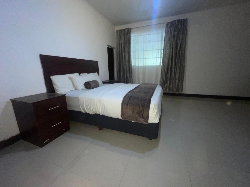 a bedroom with a large bed and a window at Khaya Mnandi Leisure Suites in Pretoria