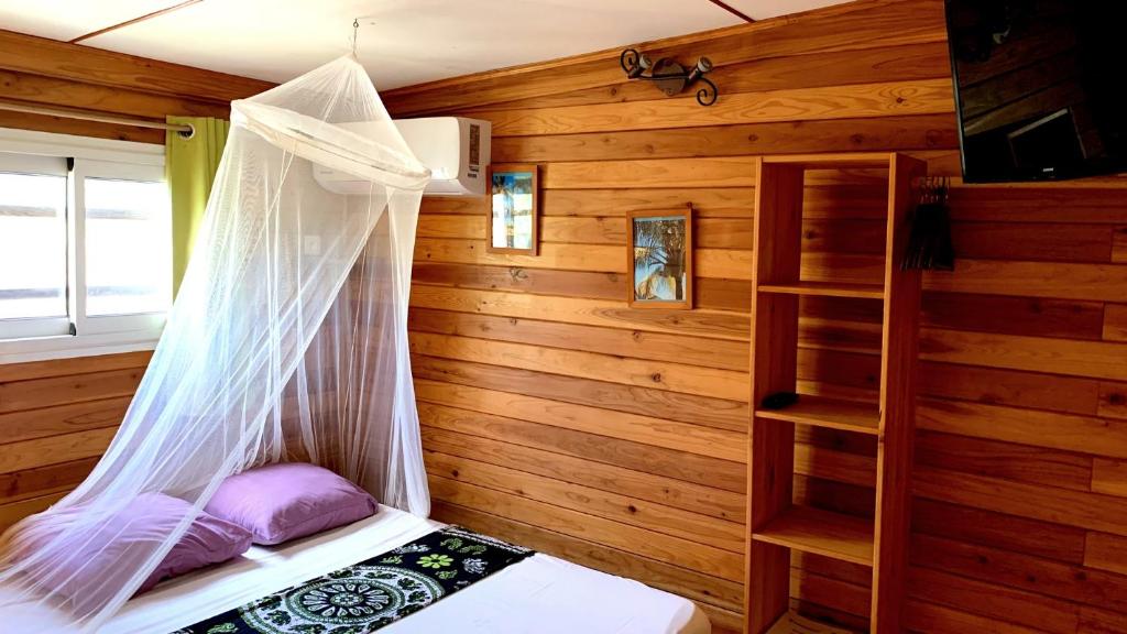 a bedroom with a bed with a mosquito net at Cazadodo in Étang-Salé