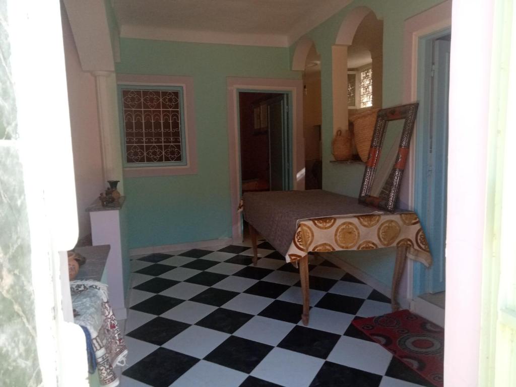 Cette chambre est dotée d'un sol en damier noir et blanc. dans l'établissement auberge djebel rose 2, à Tafraout