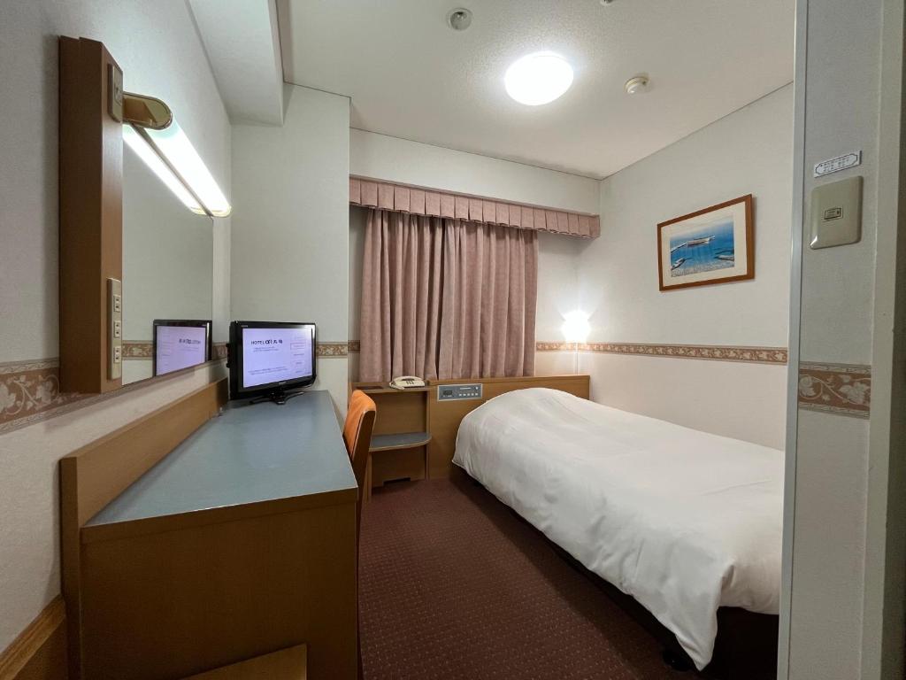 Pokój hotelowy z łóżkiem i biurkiem z komputerem w obiekcie Hotel Alpha-One Marugame w mieście Marugame