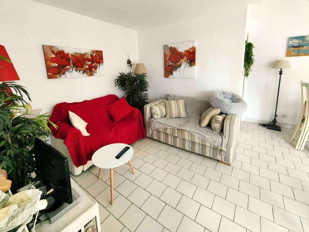 un salon avec un canapé et une table dans l'établissement Charmant T3 Mezzanine 6 pers, Piscine, Parking, Jardin Calme, Proche Plage et Commerces - FR-1-607-106, au Cap d'Agde