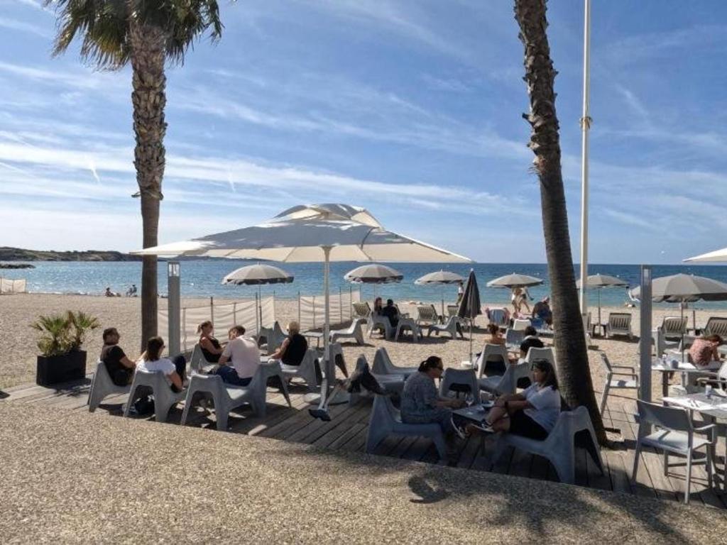 a group of people sitting in chairs on the beach at Appartement Six-Fours-les-Plages, 2 pièces, 5 personnes - FR-1-316-118 in Six-Fours-les-Plages