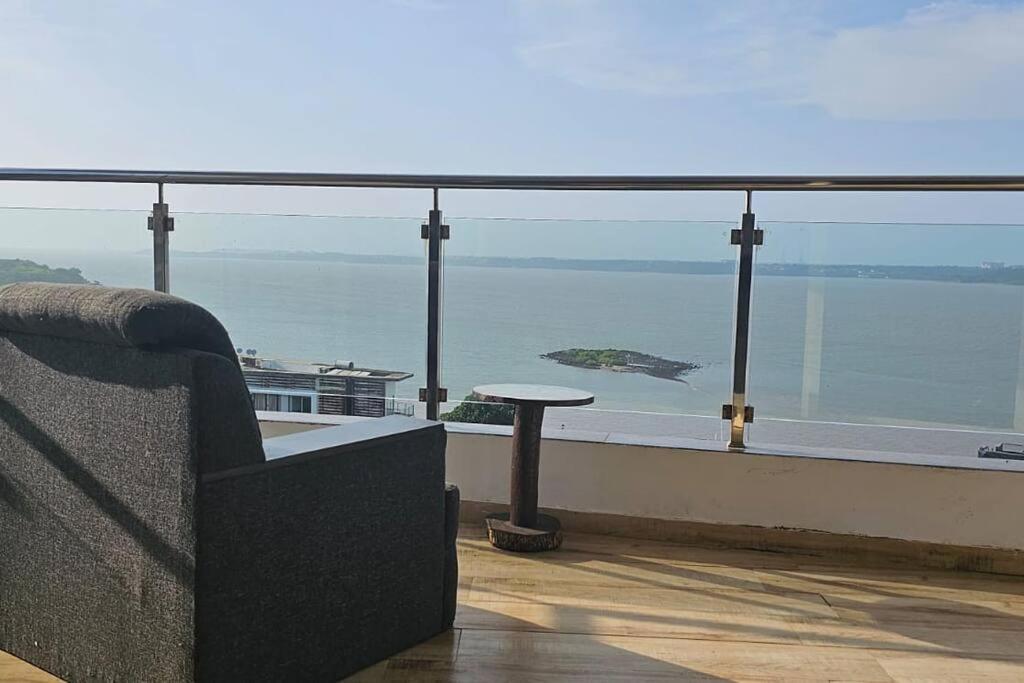 a couch sitting on a balcony looking out at the ocean at 2 BHK SKY water Apartment(SKY 2) in Marmagao