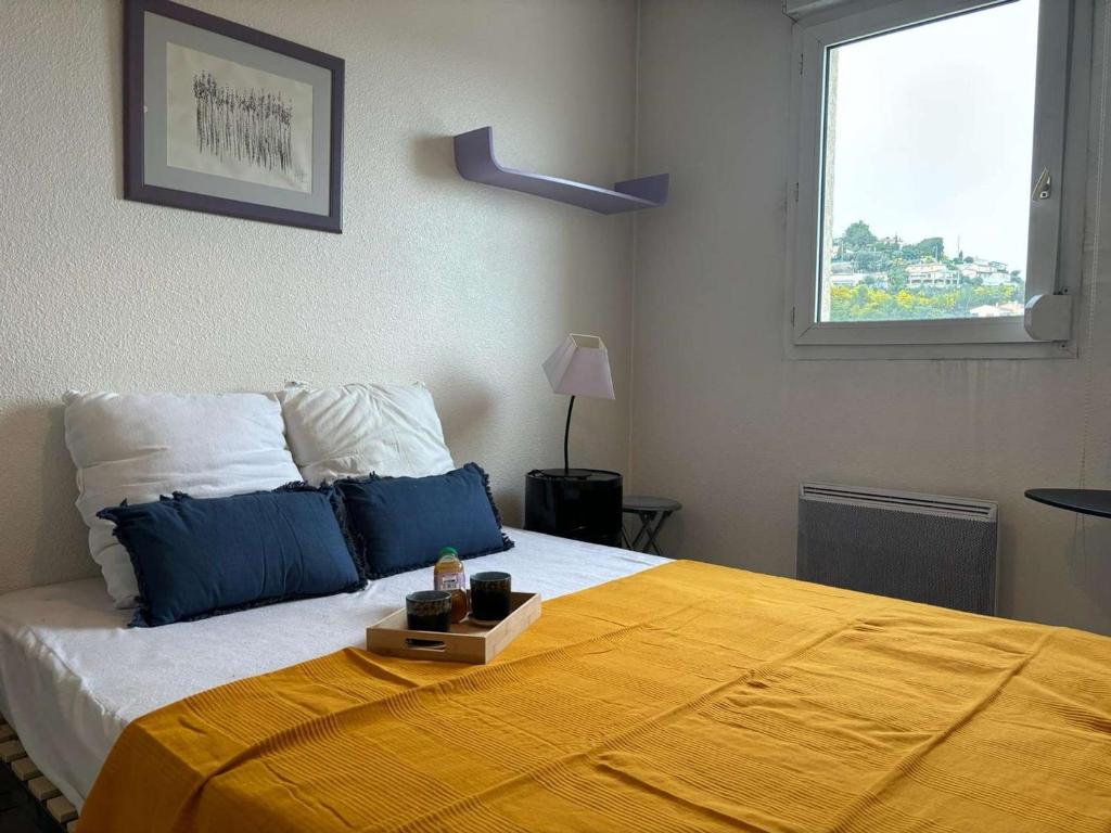 une chambre avec un lit avec une couverture jaune dessus dans l'établissement Appartement 2 pièces proche commerces à Mandelieu-la-Napoule - FR-1-609-70, à Mandelieu-la-Napoule
