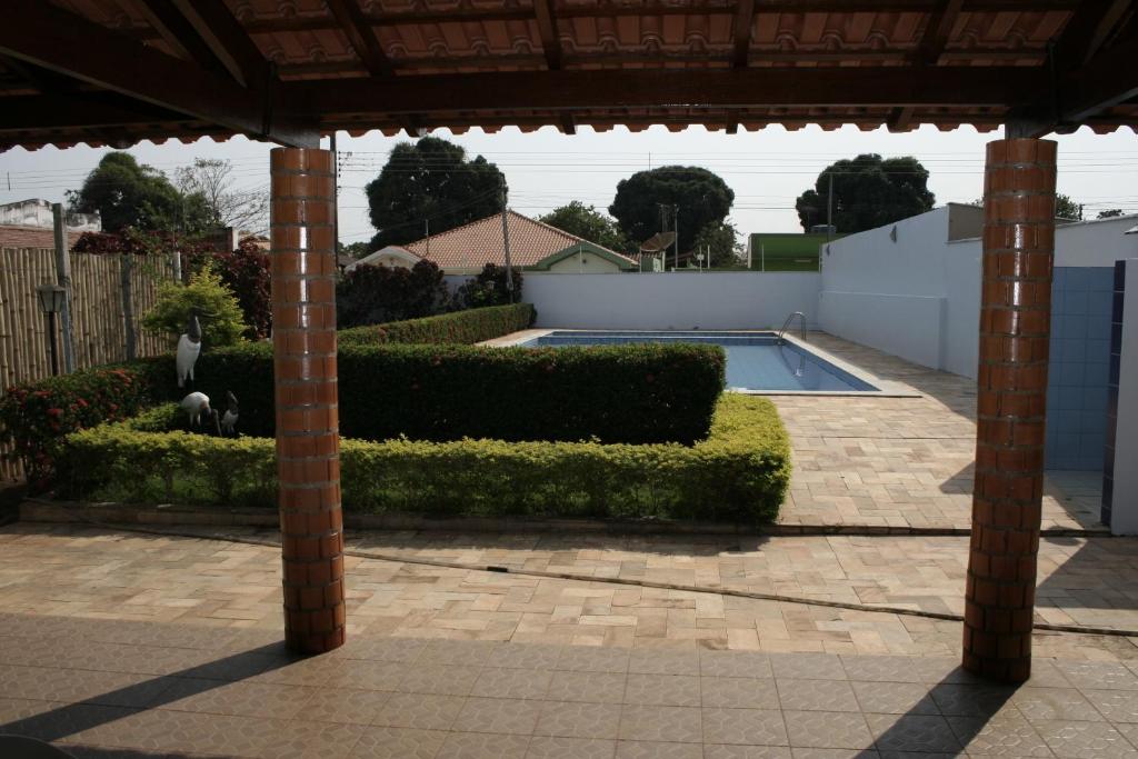 einen Pool in einem Garten mit Säulen in der Unterkunft Riviera Pantanal Hotel in Cáceres