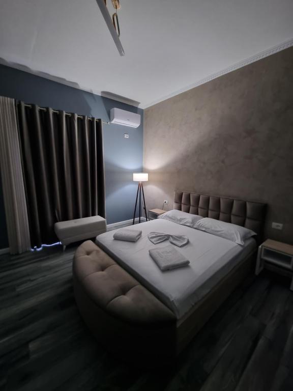 ein Schlafzimmer mit einem großen Bett und einer Lampe in der Unterkunft Vila Egeus in Berat