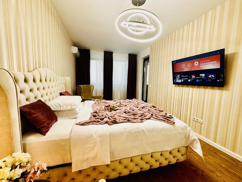 een slaapkamer met een groot bed en een tv aan de muur bij Sky Garden Panoramic View in Boekarest