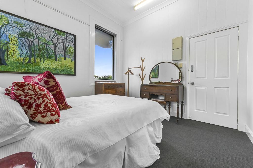 ein weißes Schlafzimmer mit einem Bett und einem Spiegel in der Unterkunft Private Windsor House Studios Apartment in Brisbane