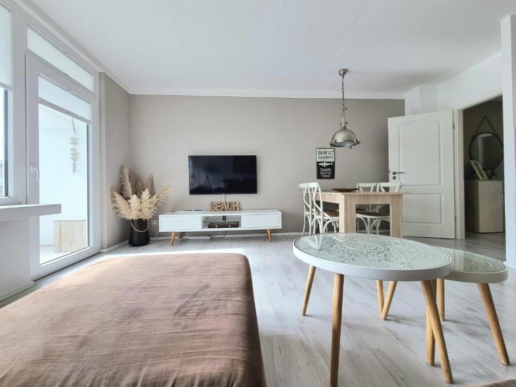 a living room with a table and a tv at Strandburg 1 in Grömitz