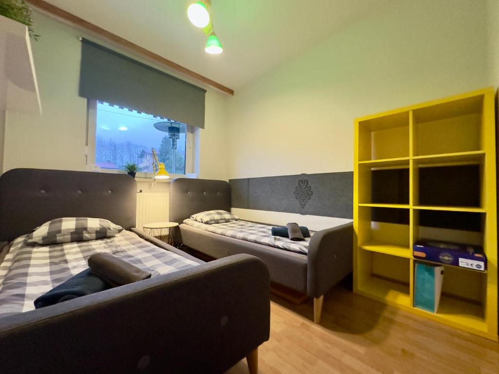 シュチルクにあるChampion's Apartment Klimatyzacja Balkon Garażのリビングルーム(ベッド2台、ソファ付)