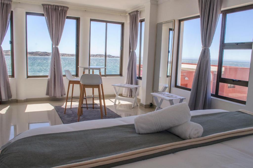 a bedroom with a bed with a view of the ocean at Shark Island Guesthouse in Lüderitz