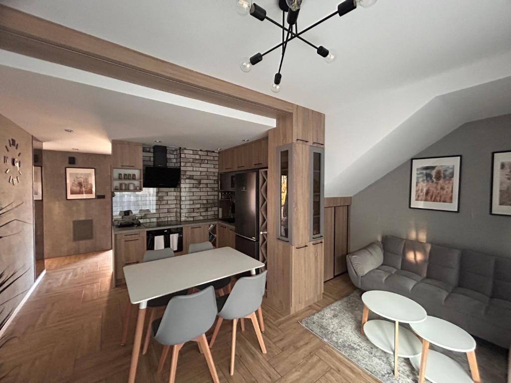 Apartament DELUX في جيشوف: مطبخ وغرفة معيشة مع طاولة وكراسي