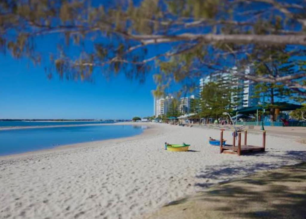 a beach with a boat on the sand and the water at Sapphire Ocean Views on the Broadwater in Gold Coast