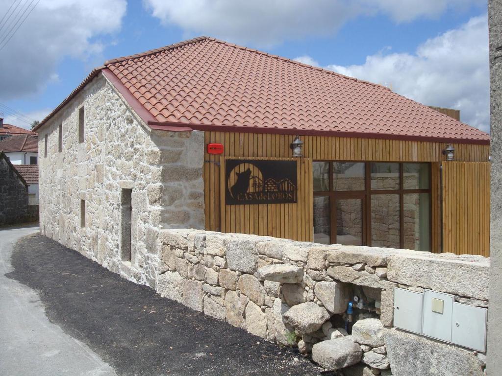 een stenen gebouw met een bakstenen muur en een bord erop bij Casa de Lobos in Cabeceiras de Basto
