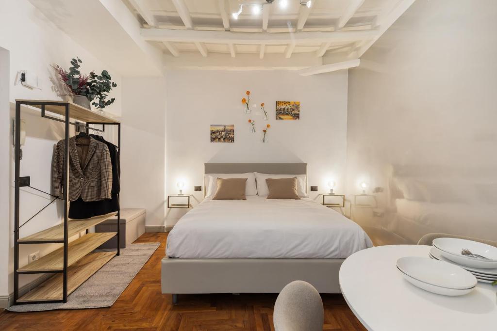 een witte slaapkamer met een bed en 2 tafels bij Fiori Suite in Rome