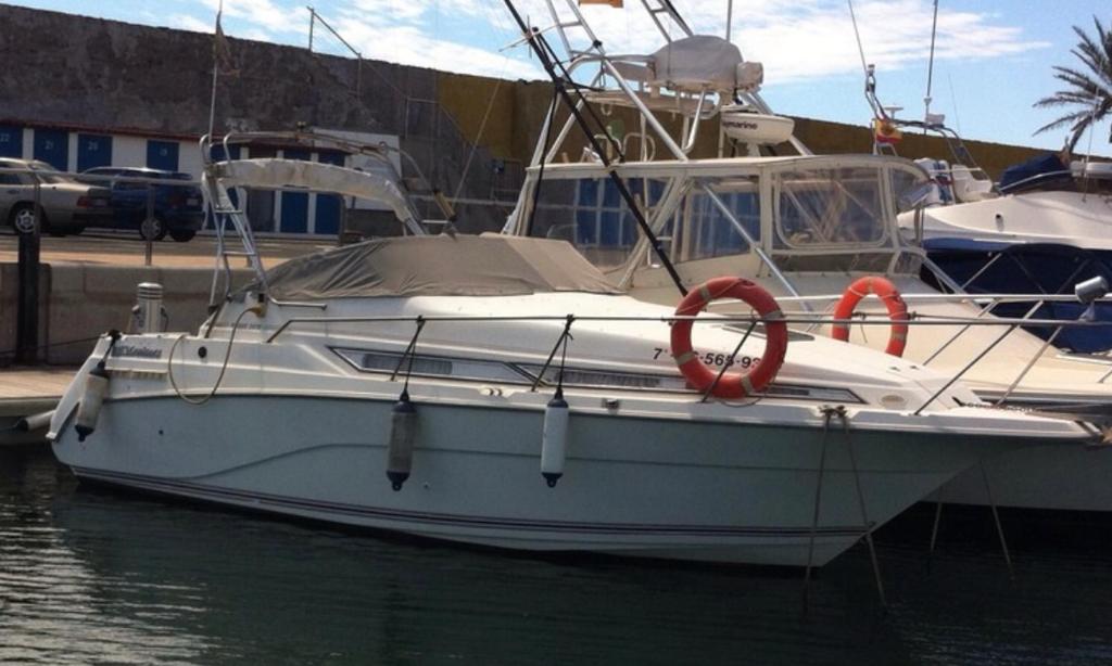 a white boat is docked in the water at Sugar Dos in Pasito Blanco