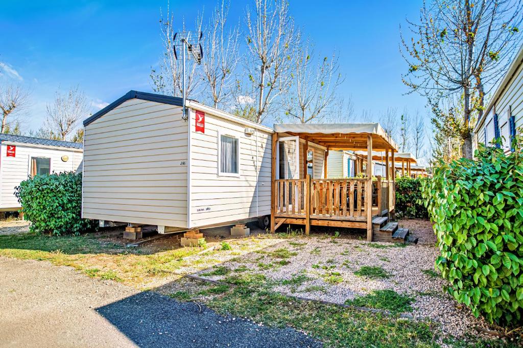 a small house with a porch and a deck at Mobil-Home Valras plage in Valras-Plage