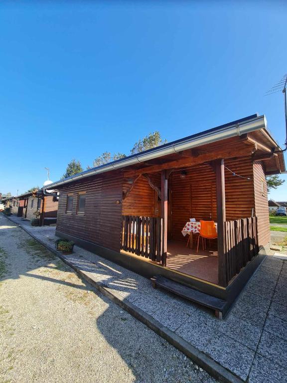 Cabaña de madera con mesa en el porche en Hiška Panonski gaj - Terme Banovci en Veržej