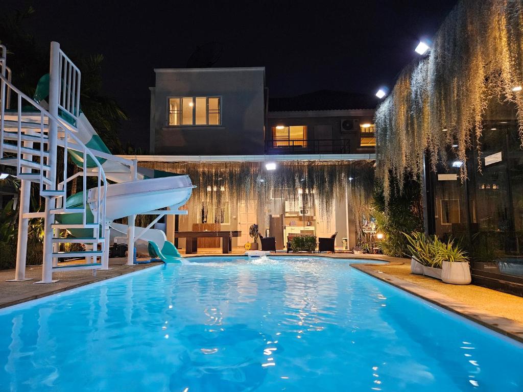 a swimming pool at night with a slide at My Home Pool Villa Hatyai in Hat Yai