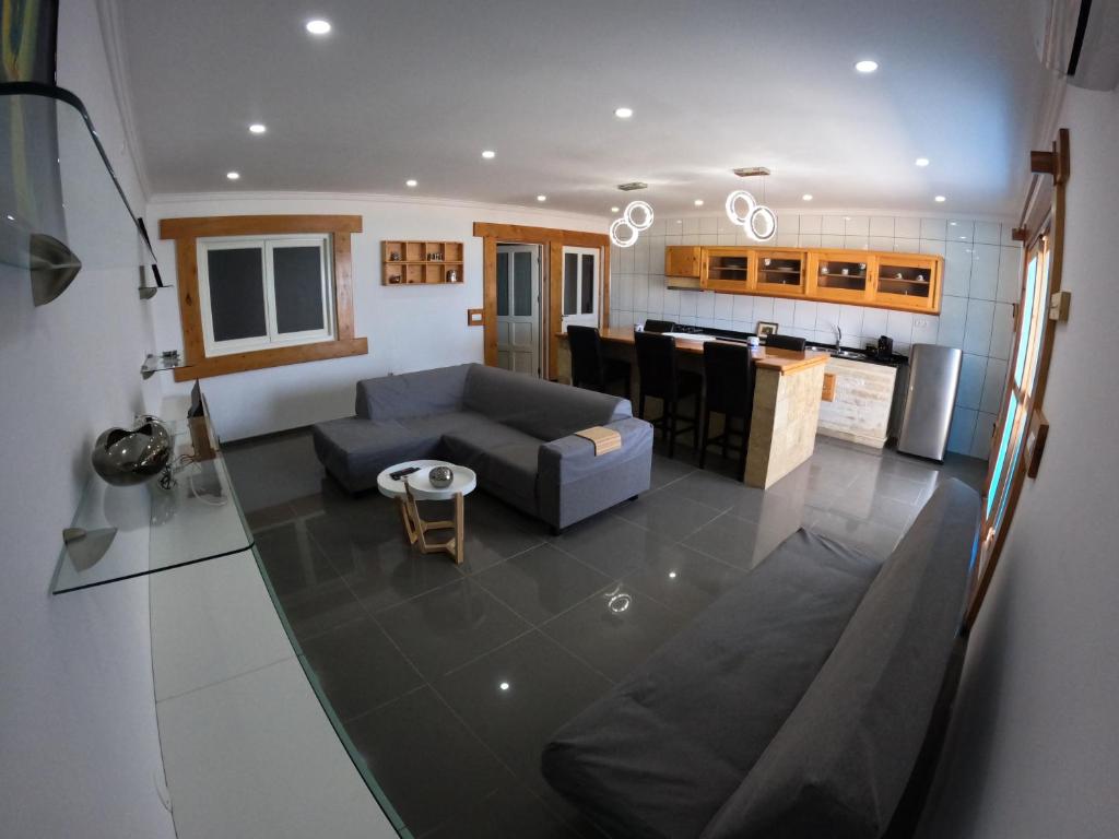 uma sala de estar com um sofá e uma cozinha em Moreira Estates na Vila do Maio