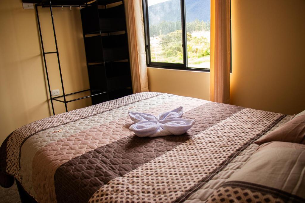 ein Schlafzimmer mit einem Bett mit einer Schleife darauf in der Unterkunft La casa de Anni in Oxapampa