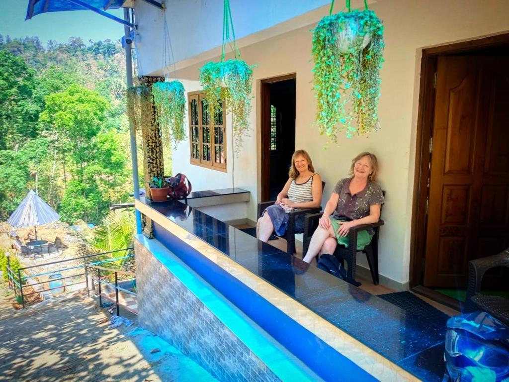 Dos mujeres sentadas en el mostrador de una casa en Mistey Valley Munnar, en Anachal
