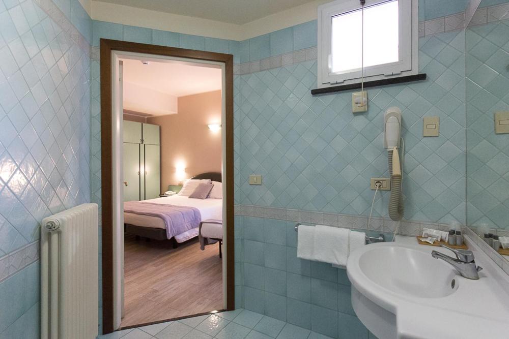A bed or beds in a room at Hotel Trevi Riccione, in centro sul mare con cucina