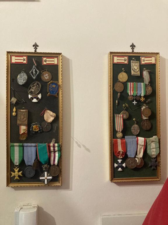 two framed pictures of medals and otherabilia on a wall at Appartamento anche solo pomeriggio in Reggio di Calabria