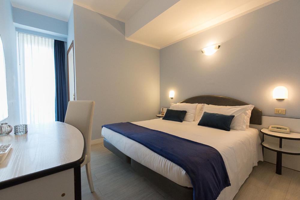A bed or beds in a room at Hotel Trevi Riccione, in centro sul mare con cucina