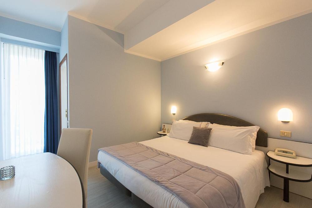 A bed or beds in a room at Hotel Trevi Riccione, in centro sul mare con cucina
