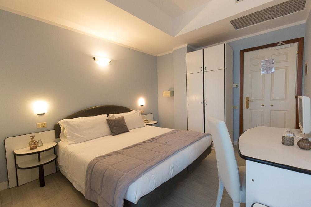 A bed or beds in a room at Hotel Trevi Riccione, in centro sul mare con cucina