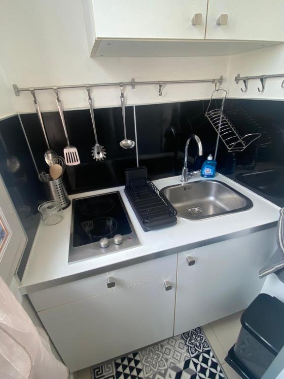 a small kitchen with a sink and a counter top at Emplacement exceptionnel et rare Paris Suresnes longchamp in Suresnes