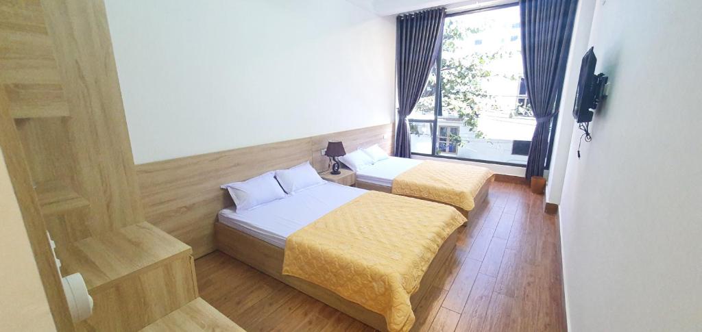 um quarto de hotel com duas camas e uma janela em Khách Sạn Hoàng Nam-Cửa Lò-Nghệ An em Thương Xà (2)