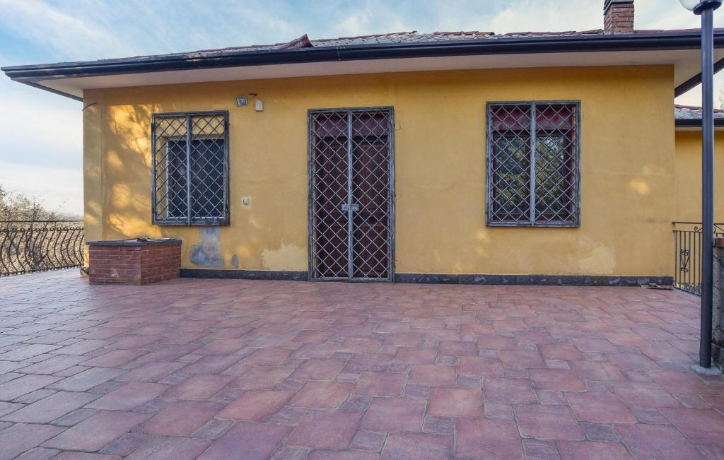 una casa gialla con un vialetto di mattoni di Lovely Home In Linguaglossa With Wifi a Linguaglossa