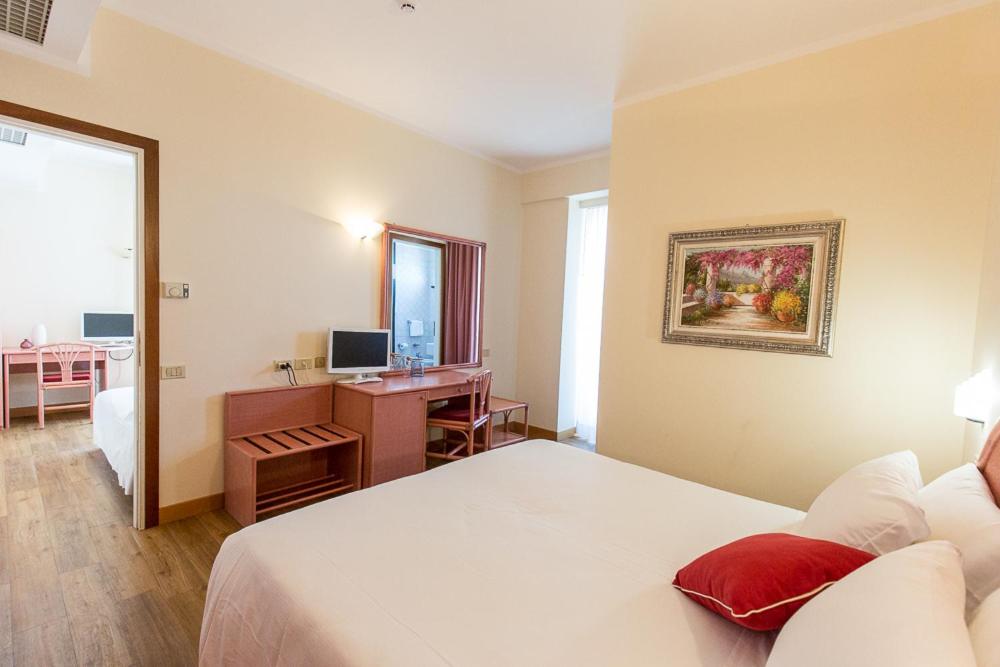 A bed or beds in a room at Hotel Trevi Riccione, in centro sul mare con cucina