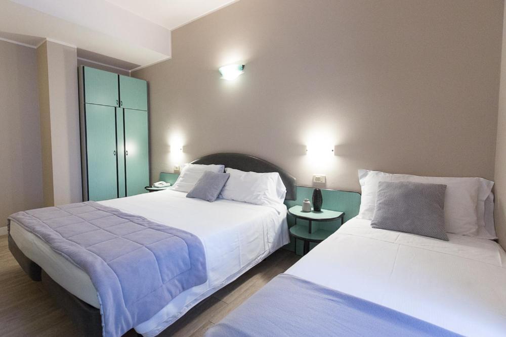 A bed or beds in a room at Hotel Trevi Riccione, in centro sul mare con cucina