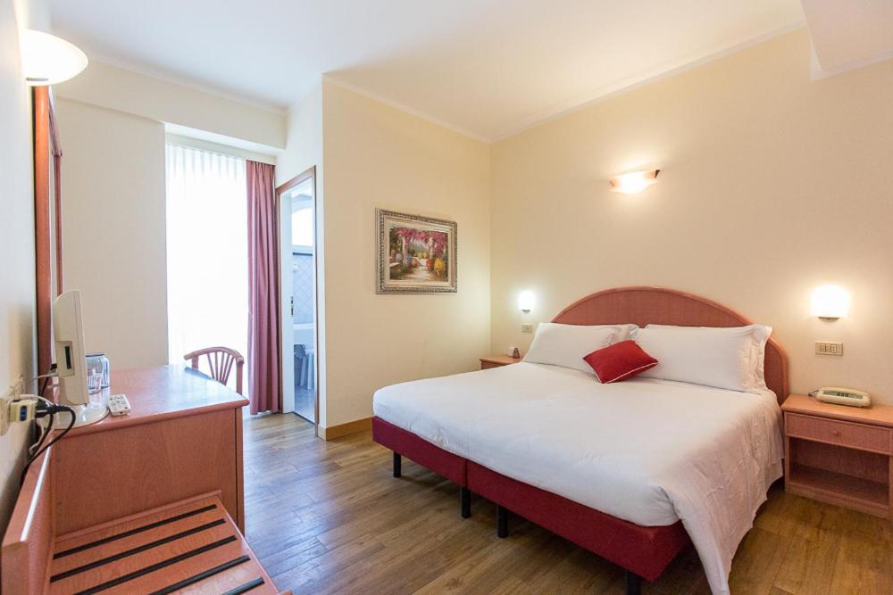 A bed or beds in a room at Hotel Trevi Riccione, in centro sul mare con cucina