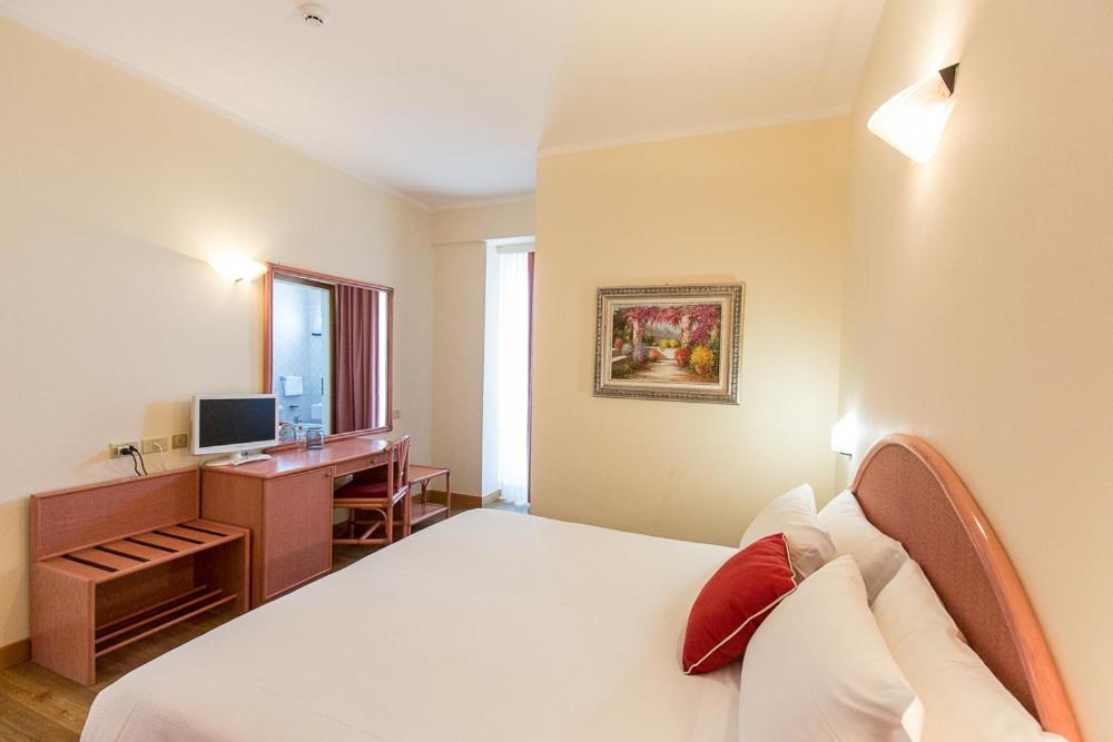 A bed or beds in a room at Hotel Trevi Riccione, in centro sul mare con cucina