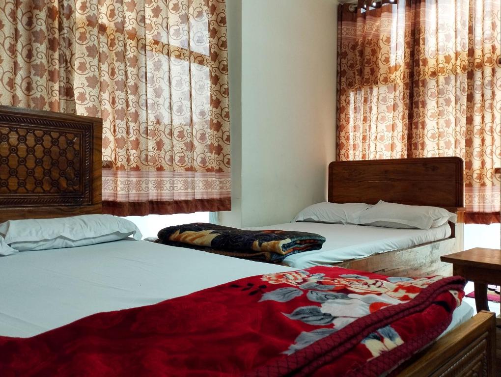 two beds sitting next to each other in a bedroom at New Hotel Labbaik 3 in Dhaka