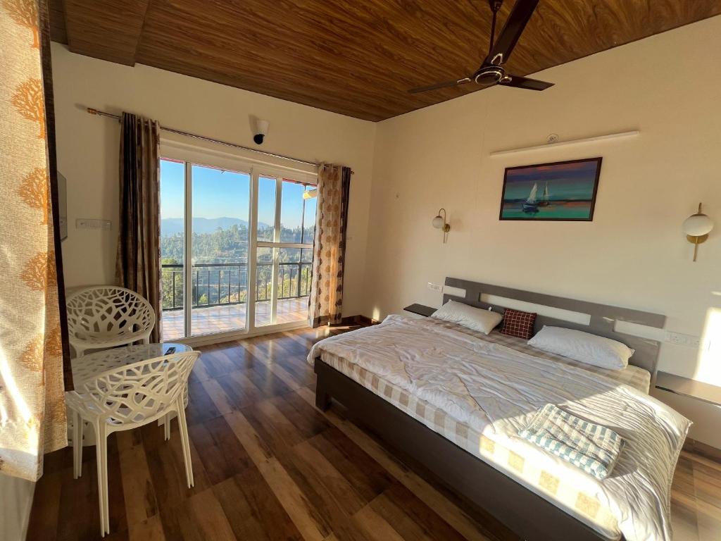 1 dormitorio con cama y ventana grande en ValleyView Homestay, en Mukteshwar