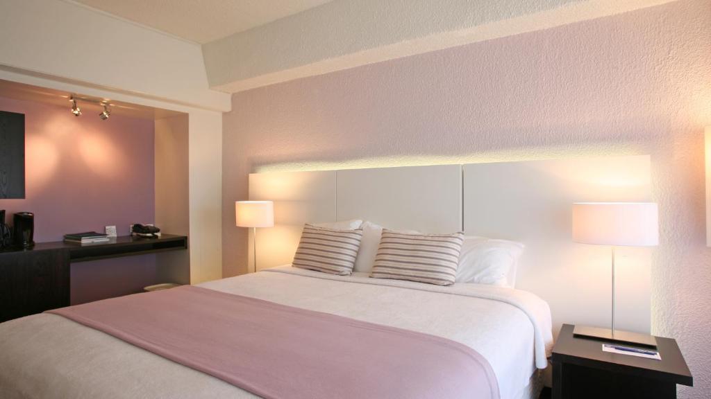 Postel nebo postele na pokoji v ubytování Holland House Beach Hotel