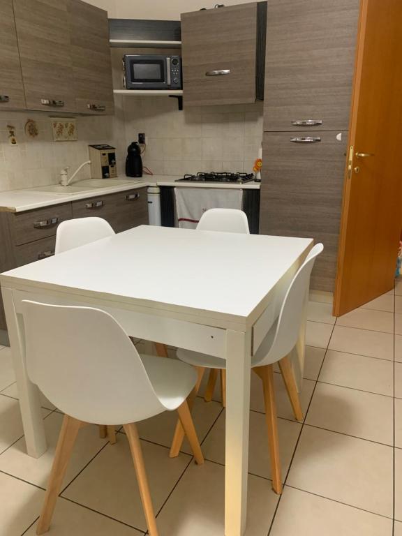 a kitchen with a white table and white chairs at Casa Vava in Uta