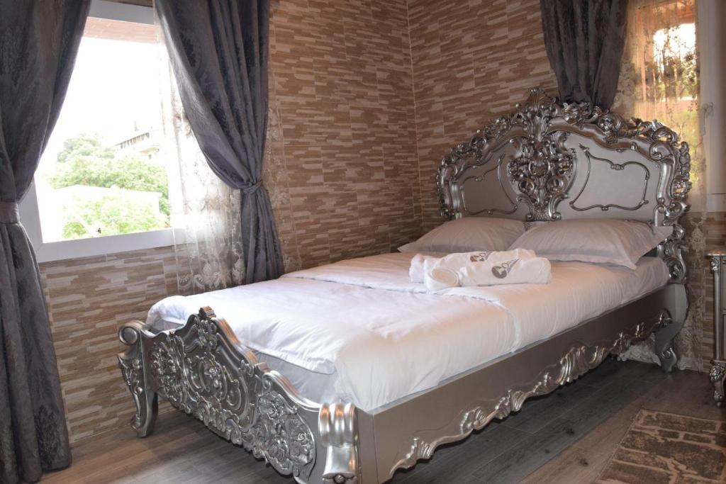 El Biar的住宿－Duplex/ Appart hotel，卧室内一张带华丽床头板的床
