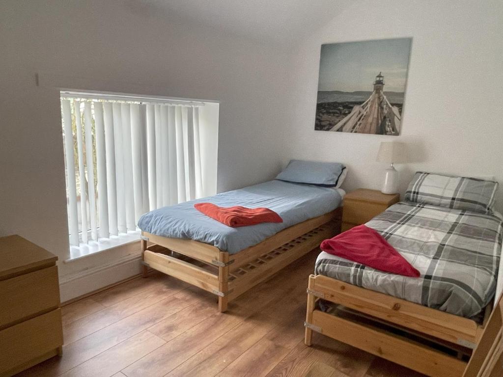 2 Einzelbetten in einem Zimmer mit Fenster in der Unterkunft 1 Fitzhamon Embankment APARTMENTS opposite Principality Stadium - free parking nearby - LONG STAY OFFER - newly redecorated March 2024 in Cardiff