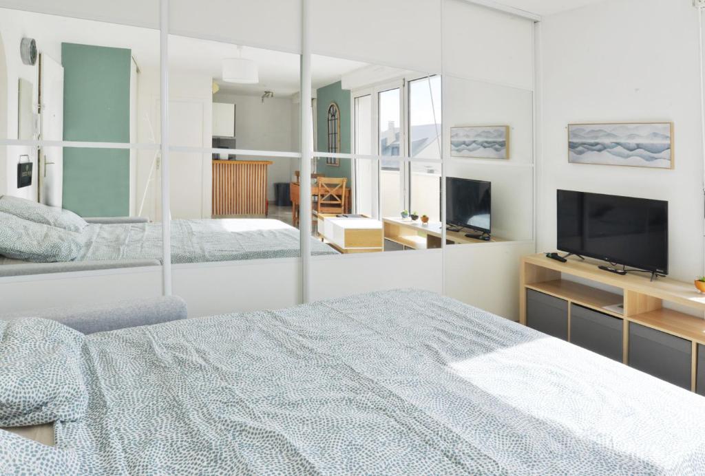 Un dormitorio blanco con una cama grande y un televisor. en Résidence Jessica à Bondoufle, en Bondoufle